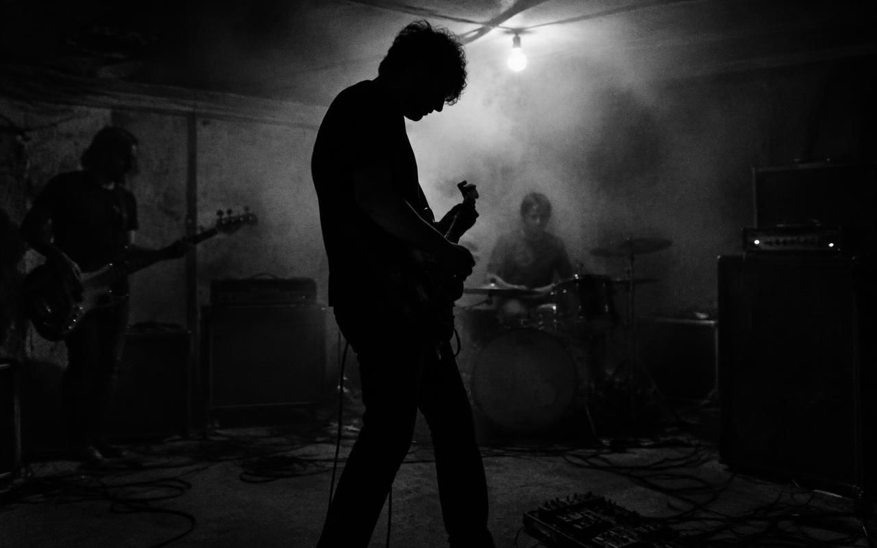 A band rehearsing in a dim, smoke-filled rehearsal room